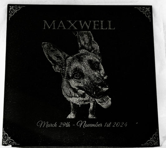 Black plaque with engraved dog illustration and text on a white background